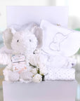 white baby shower gifts in a box with white elephant themed baby clothing and soft toy.