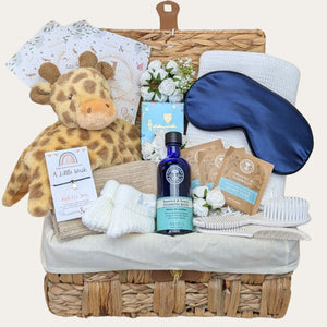 Baby shower hamper basket with gifts for mum and baby. Includes Neal’s Yard and giraffe comforter - designed by Bumbles and Boo.