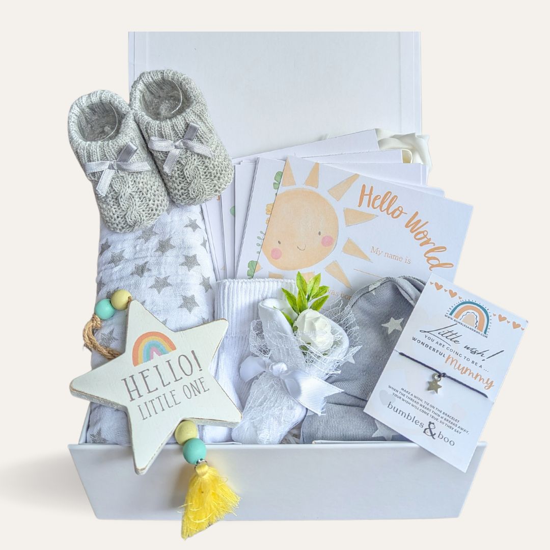 baby shower gift box with muslin, milestone cards, baby booties, mittens, socks and hat.