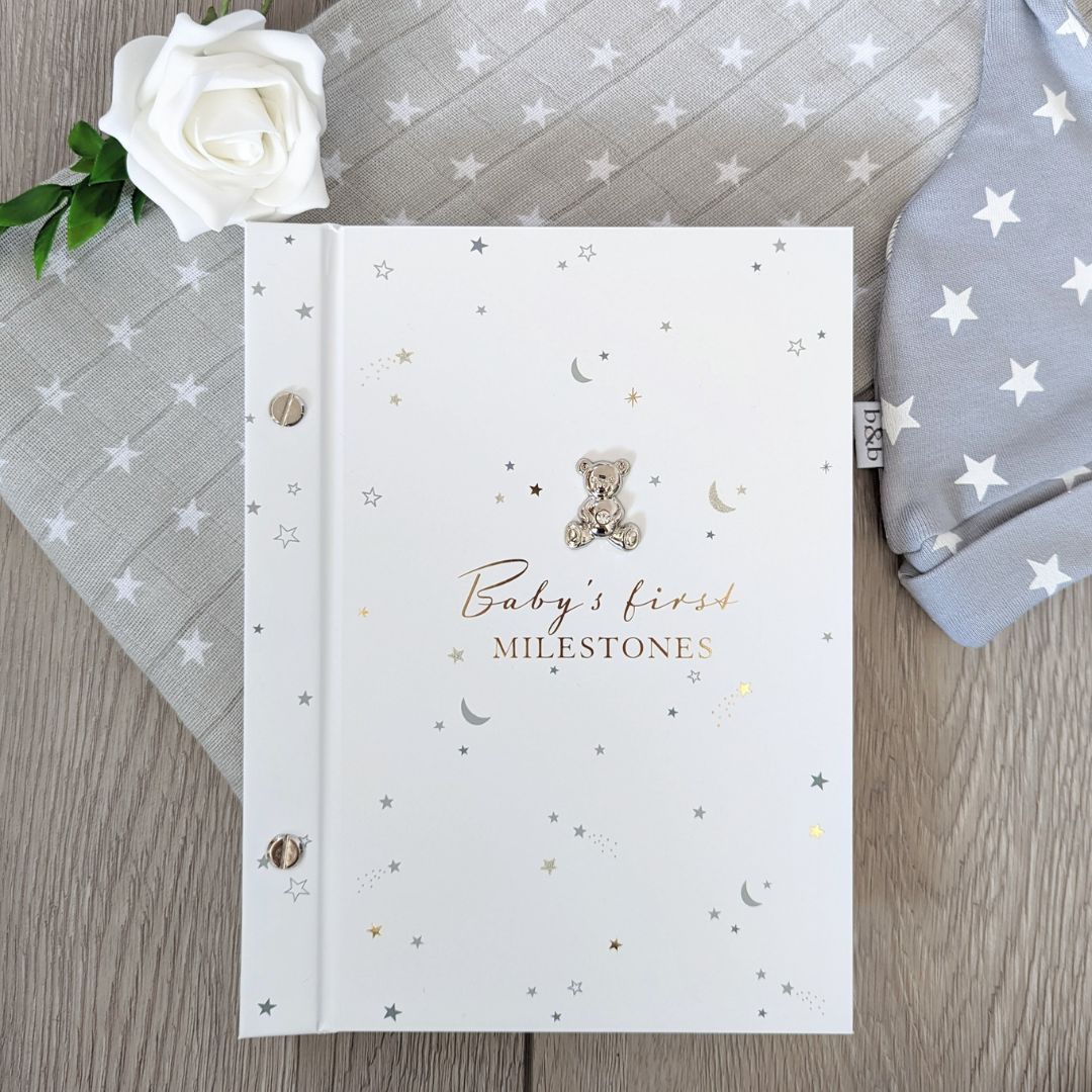 Baby's first milestones white photo album.