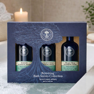 A box containing three Neal's Yard foaming bath bottles. Restoring bath scents.