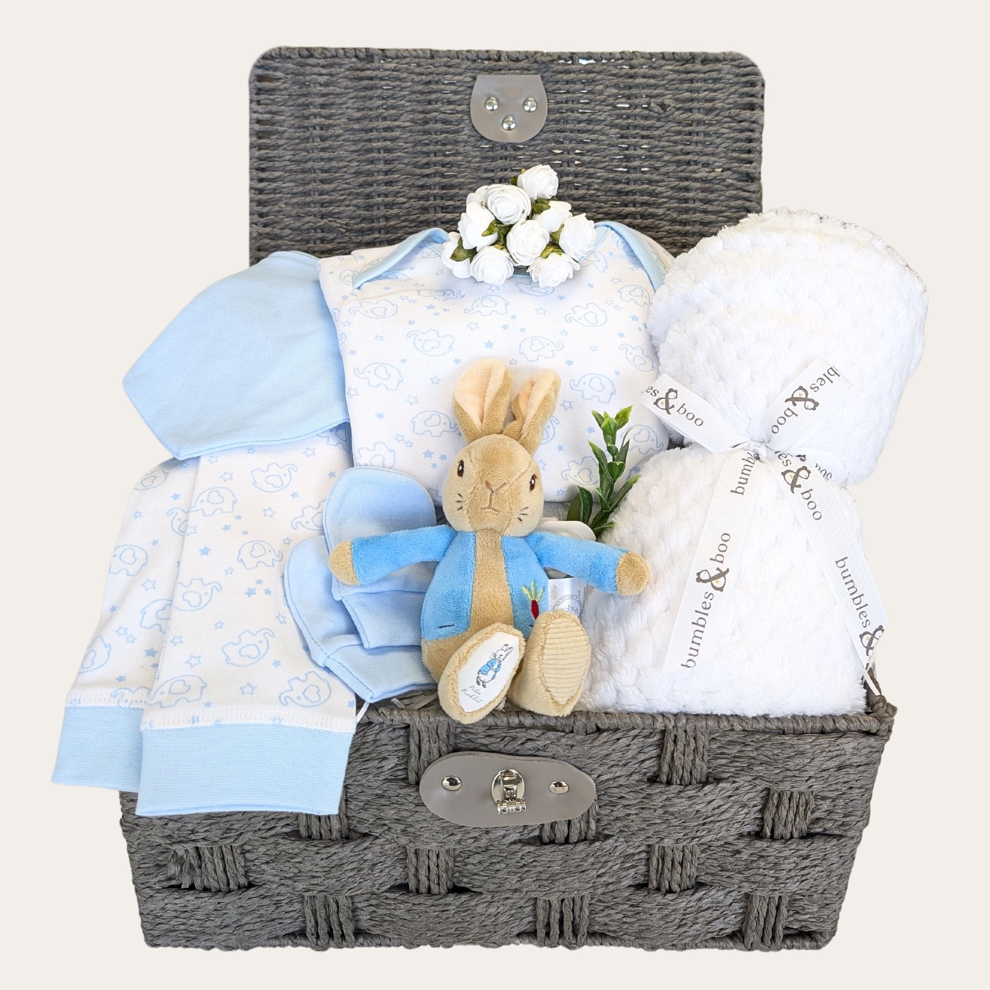 Baby boys gifts in a hamper basket with white blanket, bandana bib, pyjamas and peter rabbit soft toy. Bumbles and Boo.
