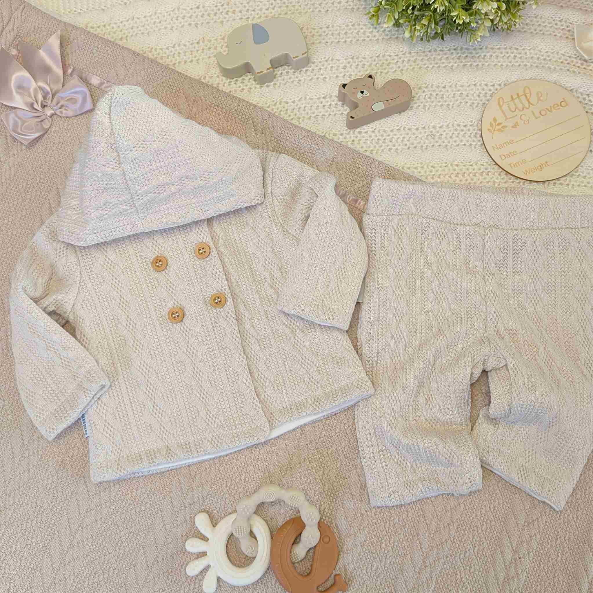 Beige baby knit clothing set with trousers and matching cardigan with buttons.