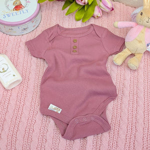 A berry pink baby girl vest made from soft recycled materials.