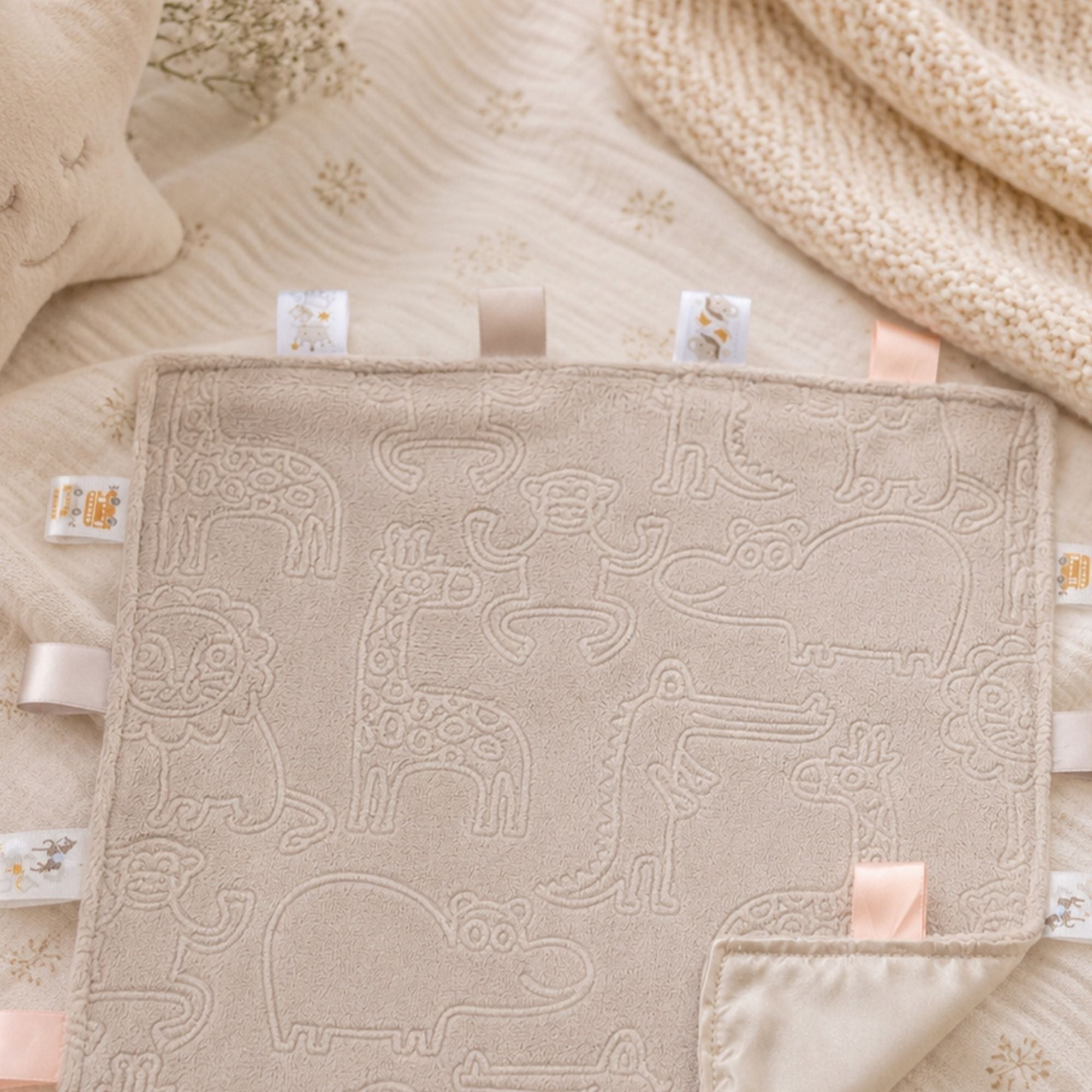 Safari animal embossed neutral biscuit coloured taggie