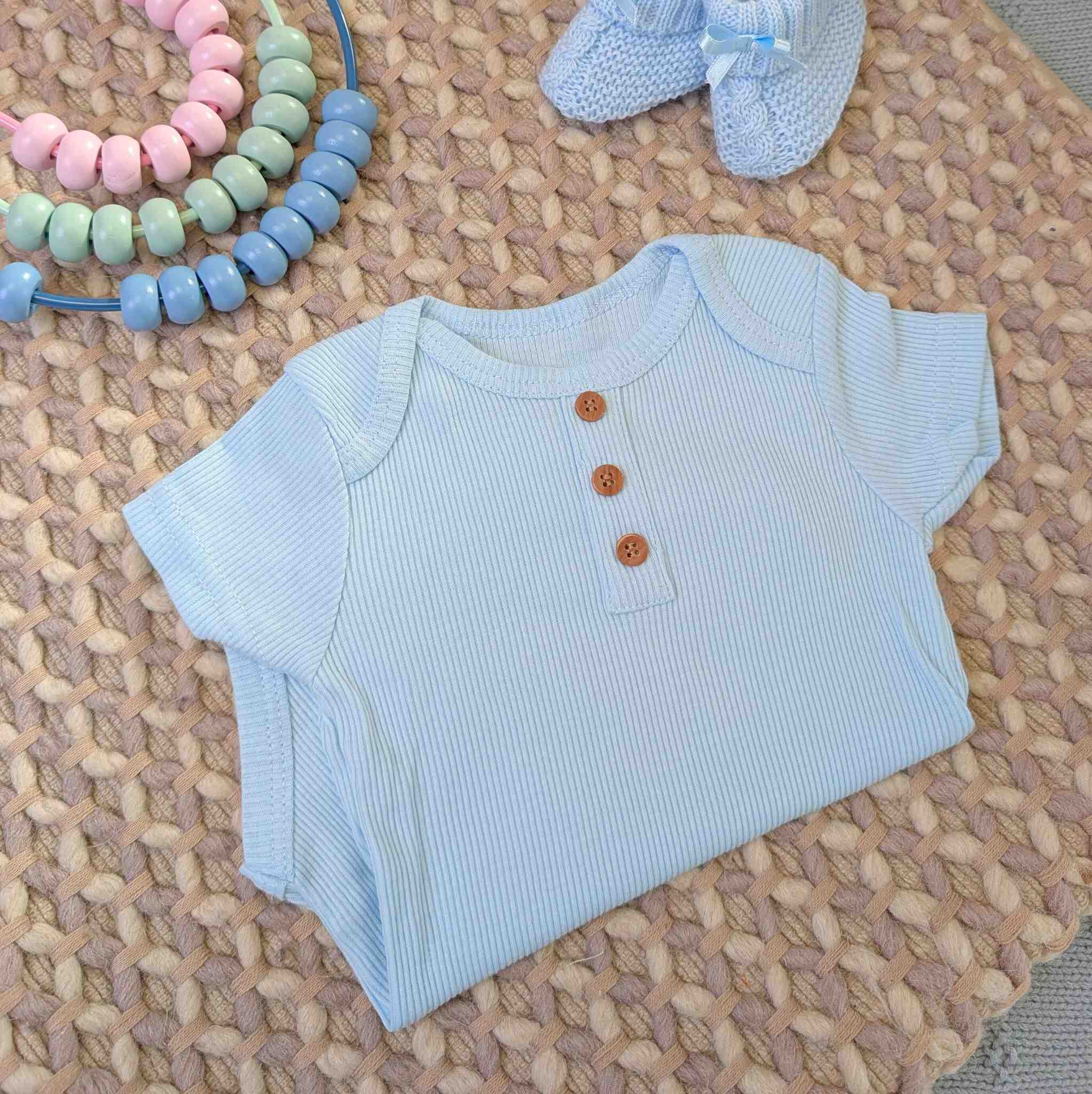 Blue baby boy vest with ribbed design and buttons.