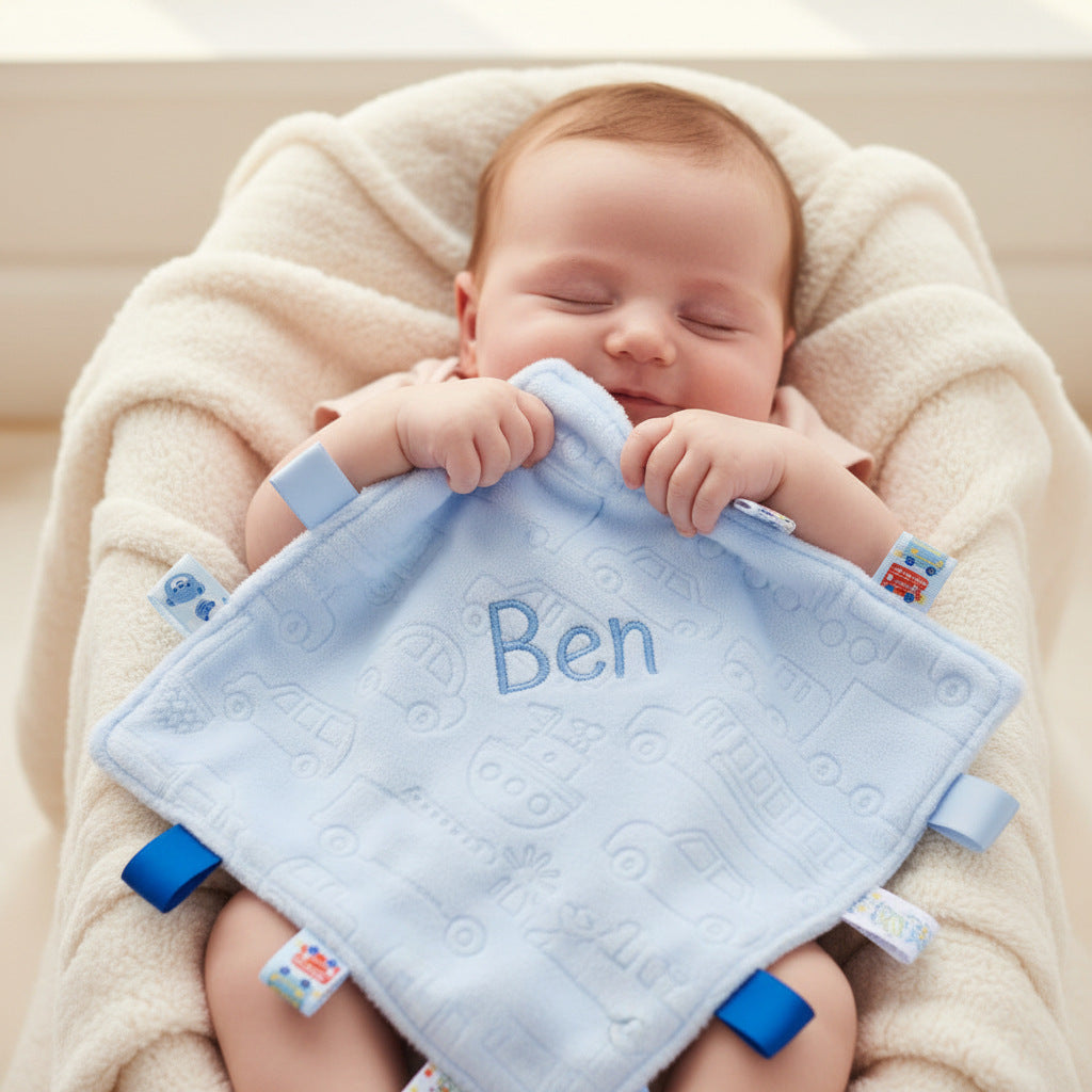 Pale blue taggie with embossed vehicle print and a satin back