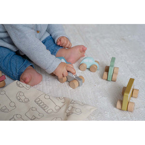 Baby playing with wooden vehicles.