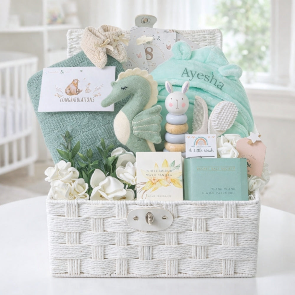 Green and cream gifts in a basket to welcome a new baby.