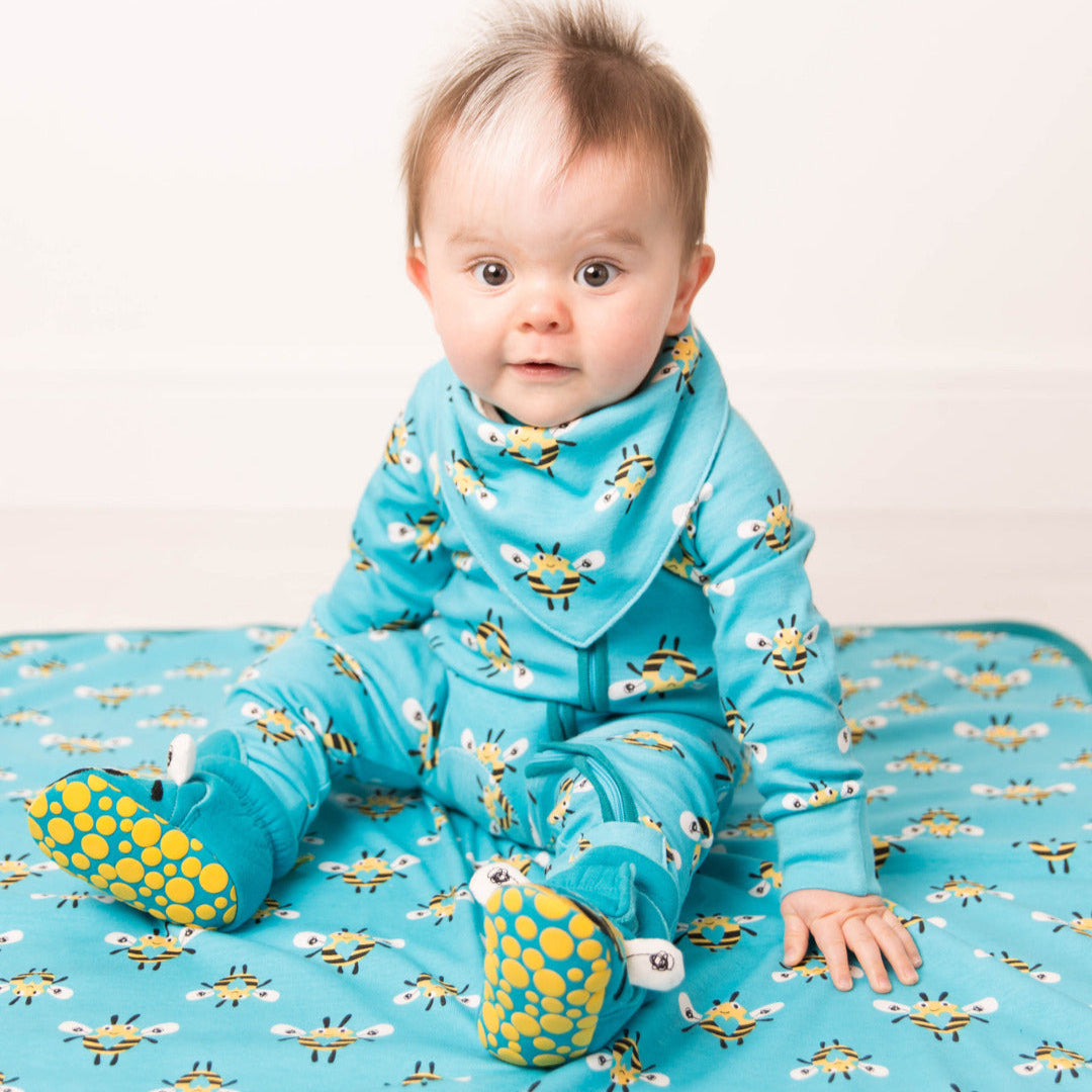Baby wearing blue Buzzy Bee romper with bee print