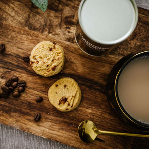 Close-up of caramel biscuits with coffee beans and latte – gourmet treat