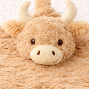 A close up of the highland cow comforter soothers face