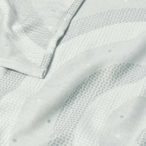 Close-up of cool grey baby blanket fabric showing quilted rainbow pattern and soft texture