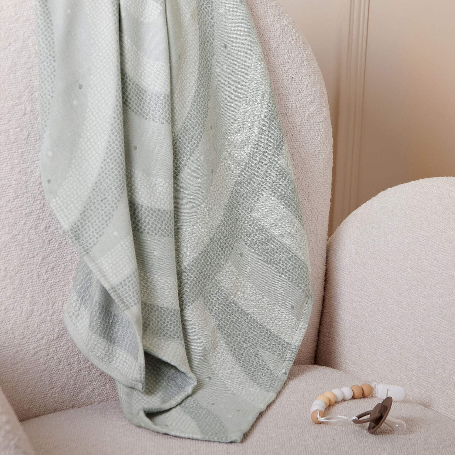 Cool grey baby blanket laid flat showing quilted rainbow pattern and printed texture.
