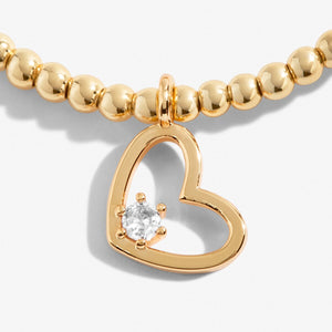 Gold Bracelet with open heart charm and clear stone detail