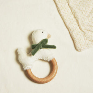 Goose ring teether beside a turned-back corner of the cream baby blanket.