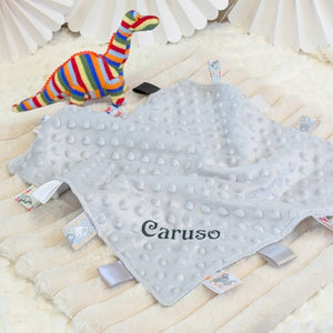 Grey baby comforter with taggie ribbons. Can be personalised with baby's name.