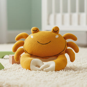 Knitted organic cotton crab baby toy in mustard yellow with soft shell and pincers