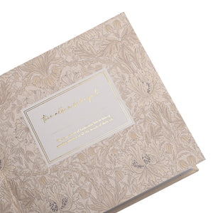 Close-up of the patterned endpaper and dedication panel inside the baby album