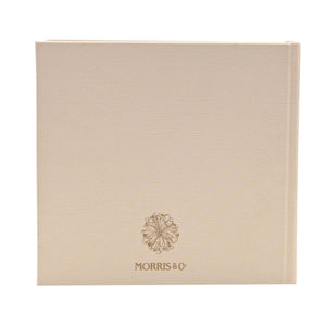 Back of neutral linen baby album with a small gold emblem