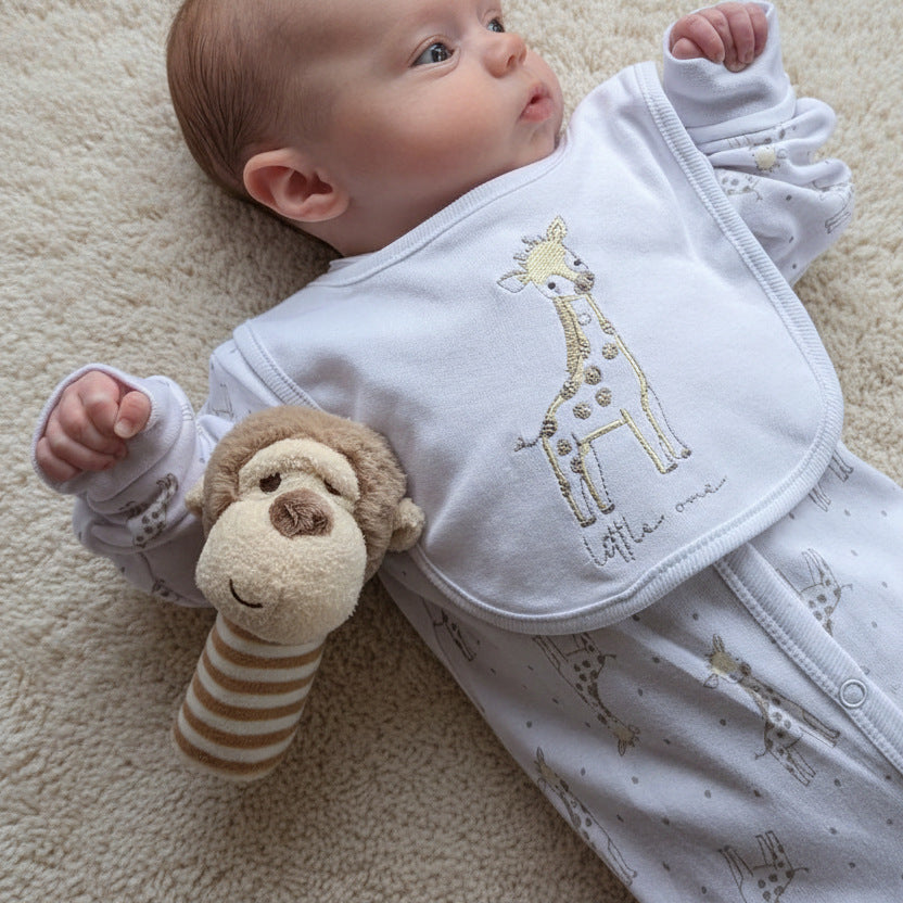 Baby rattle, monkey stick rattle next to a baby