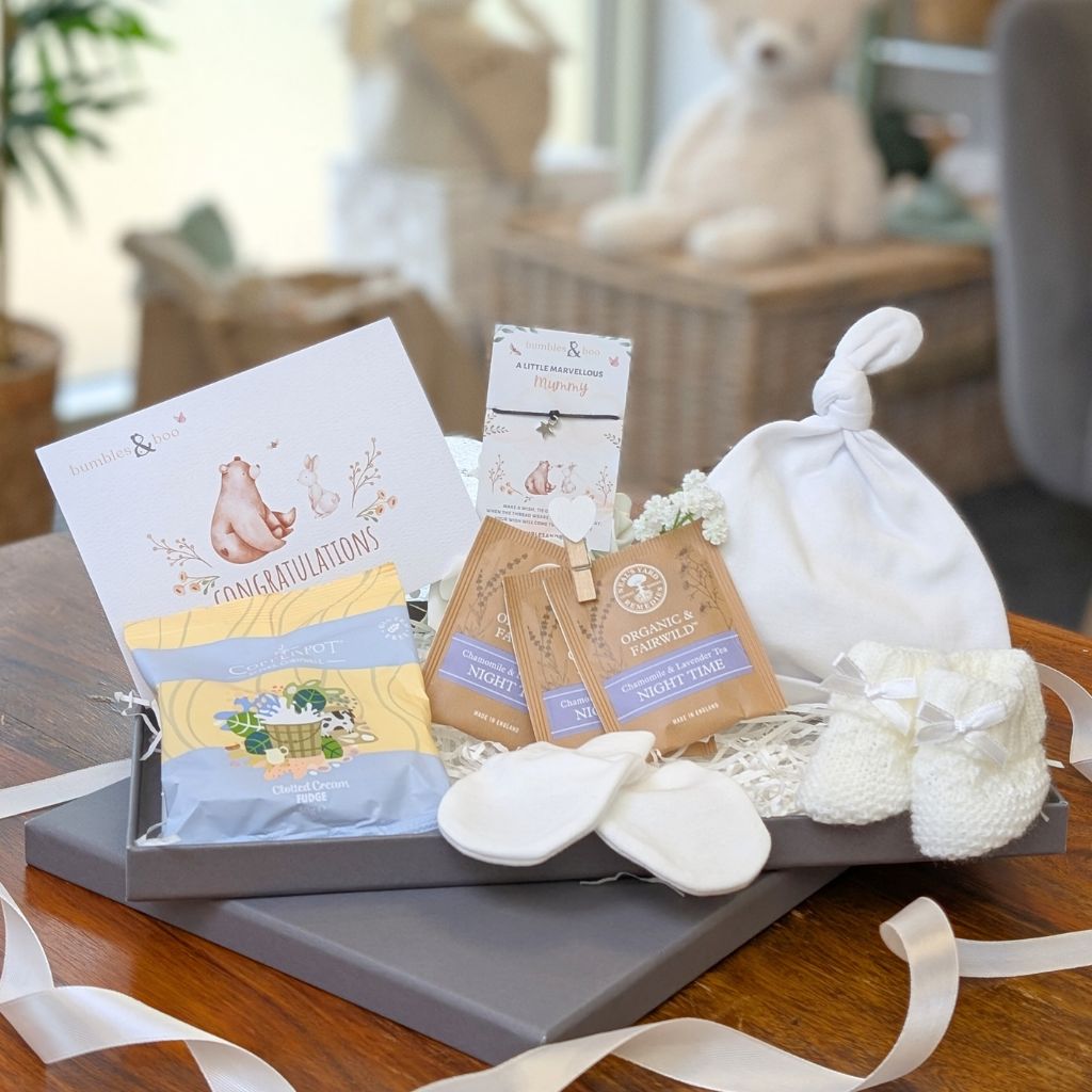 Mum to be letterbox gifts, with white presents including baby essentials, sweets and tea