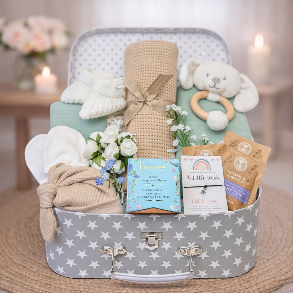 Mummy to be gifts in a grey star luggage suitcase with chocolates for mum and baby essentials