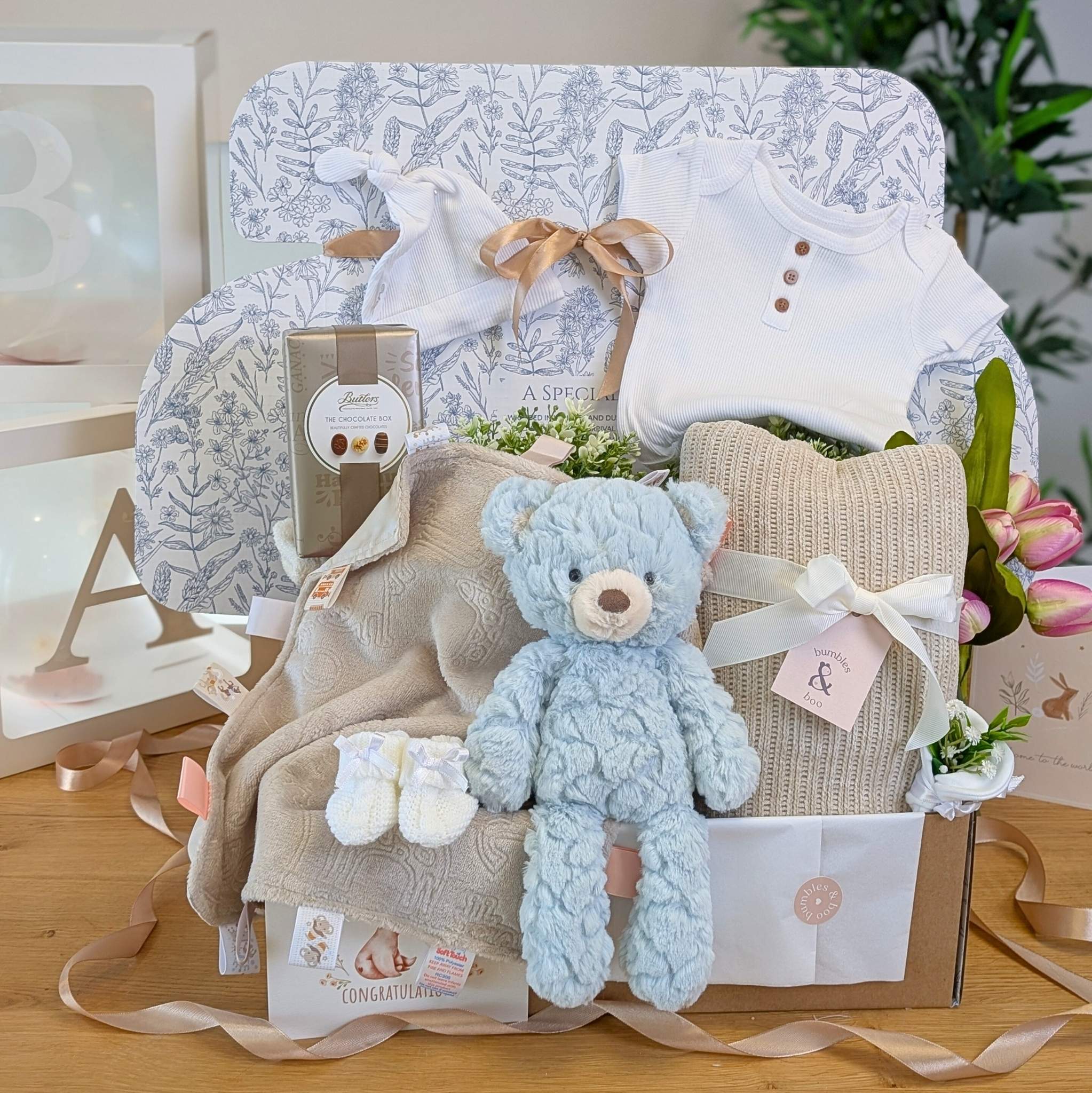 Mummy to be pregnancy gift box with white baby clothing, blue teddy and chocolates for mum