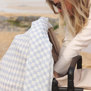 mum tucking baby into a pram