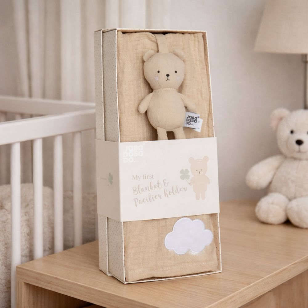 Beige teddy bear in a gift box with a dummy clip