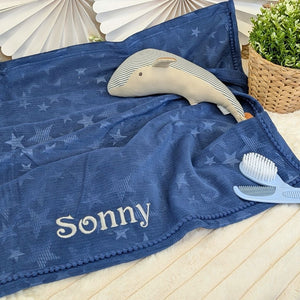 Navy blue baby blanket with star pattern and the name 'Sonny' embroidered along one side