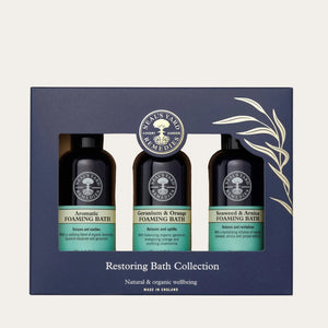 Neal's Yard Restoring Bath Collection with three foaming bath bottles on a white background
