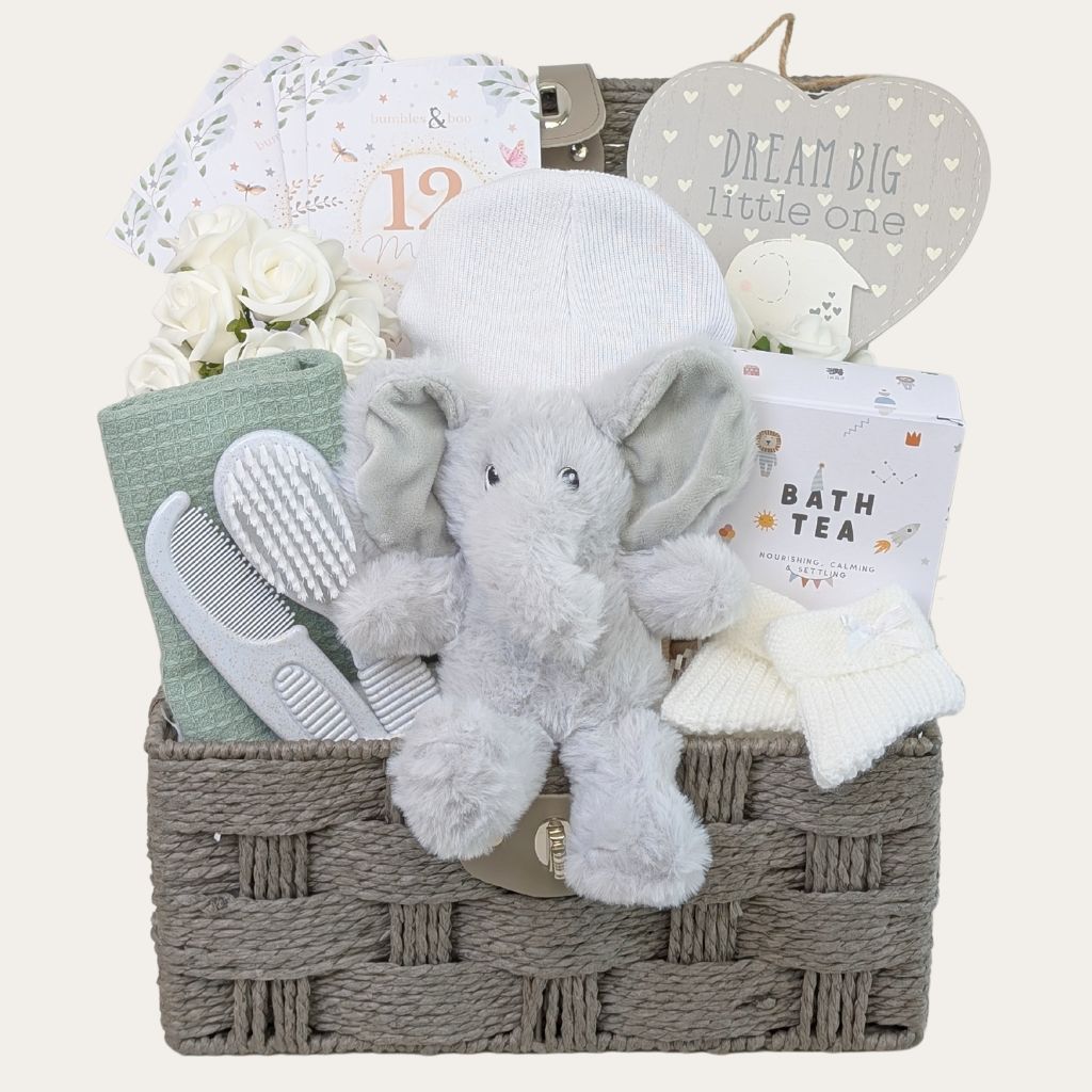 White and green new baby gifts in a hamper basket. Bumbles and Boo.