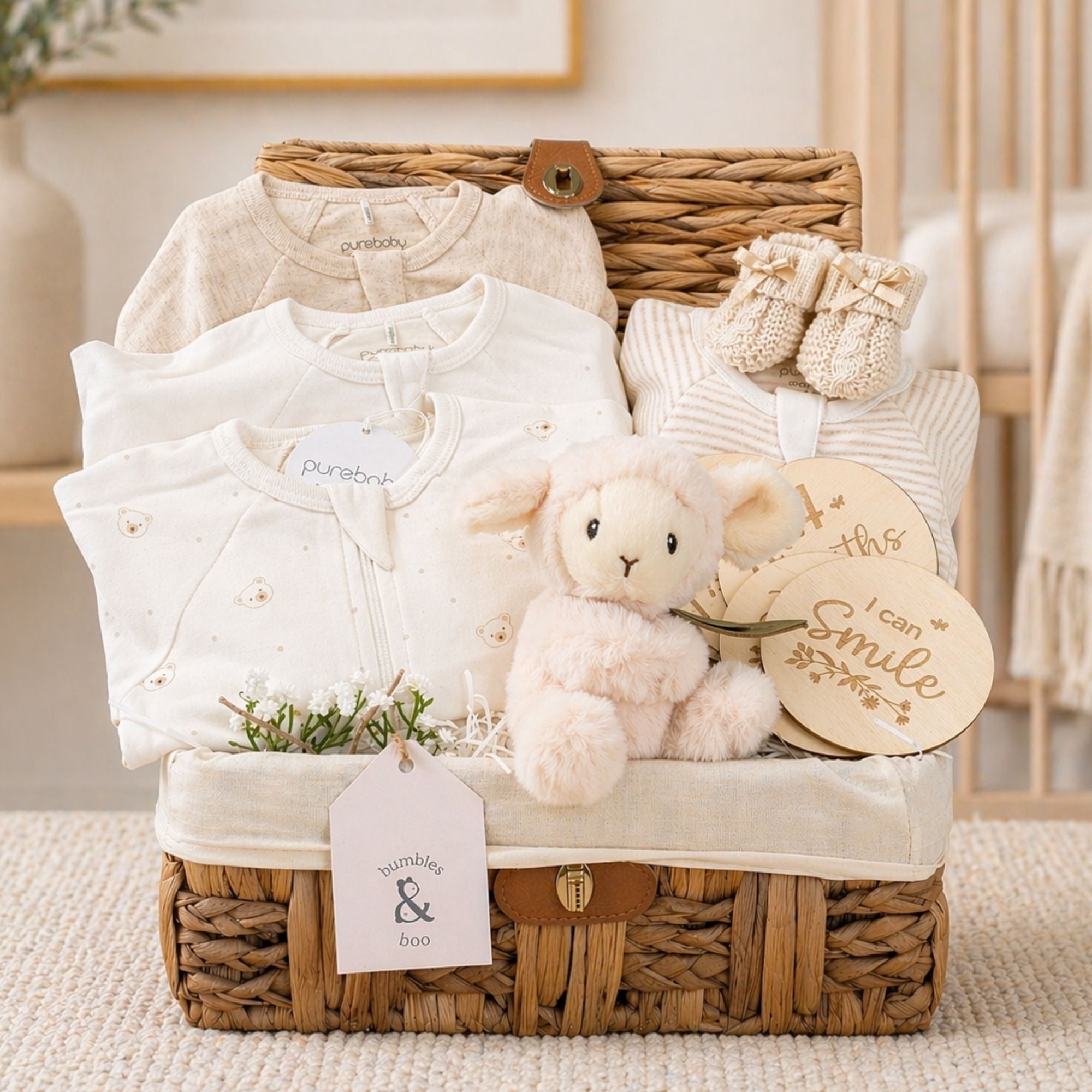 Baby hamper gifts in a basket with organic baby clothing and lamb soft toy.