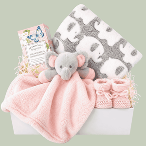 gifts for a baby girl in a white magnetic box with elephant comforter and elephant blanket