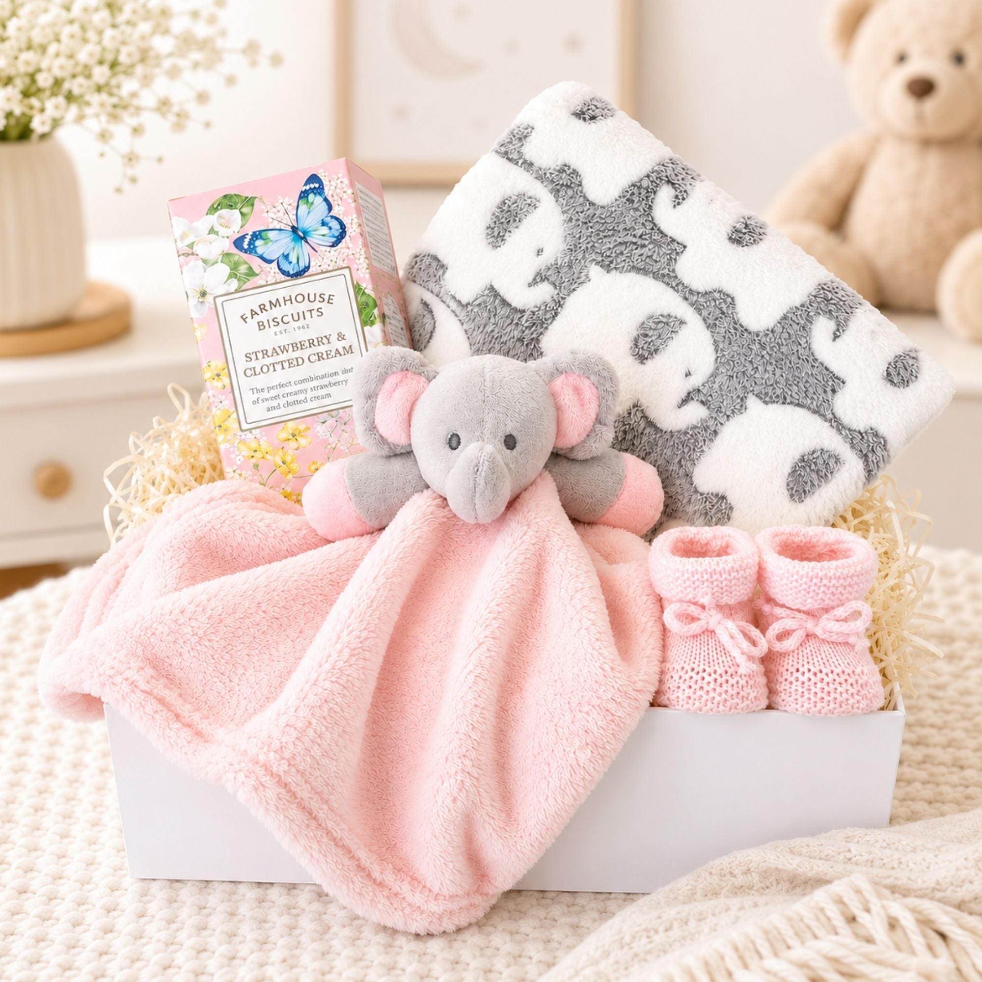 Hamper gifts for a baby girl in a white magnetic box with elephant comforter and elephant blanket