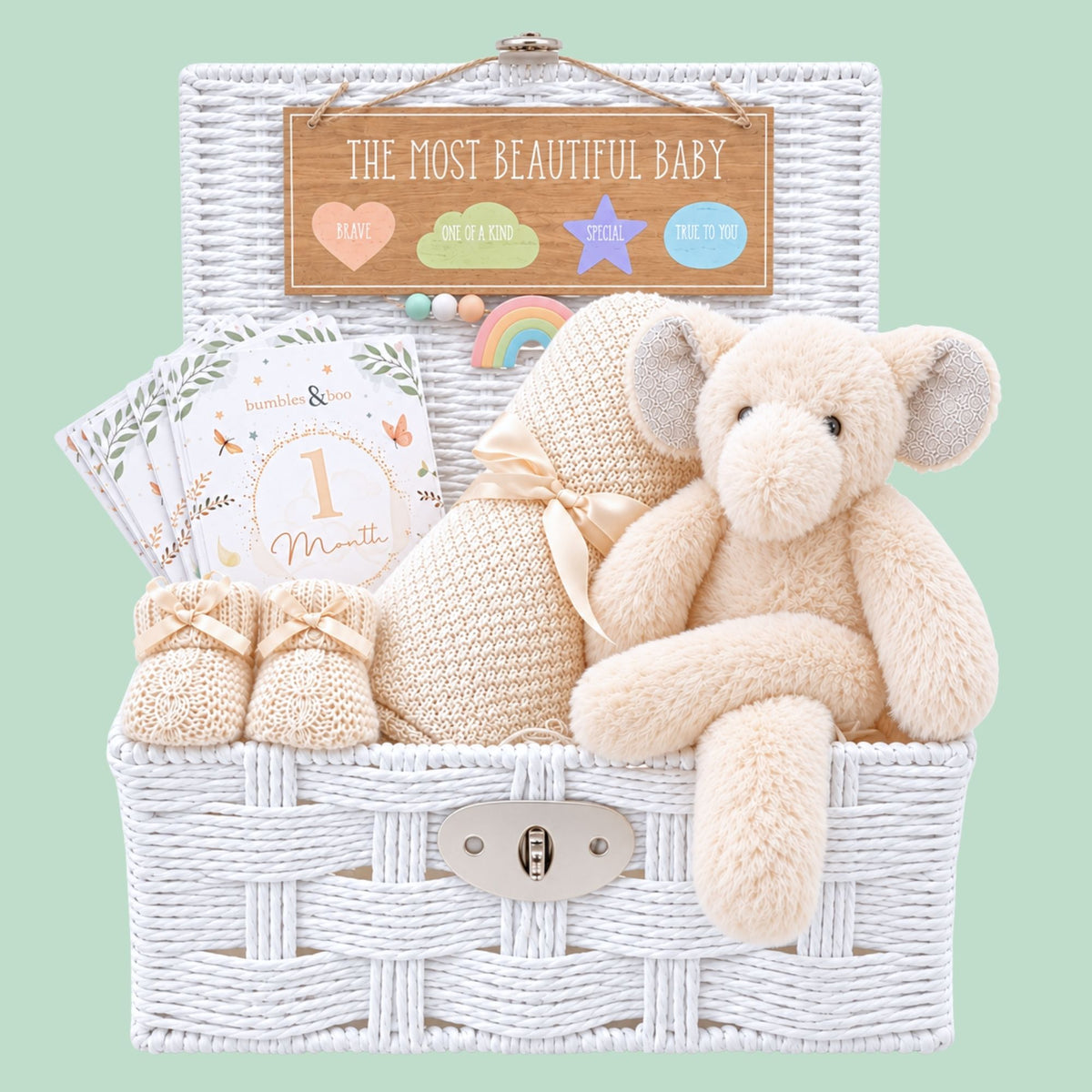 New baby hamper basket with a cream elephant theme and bamboo blanket presented in a white basket.