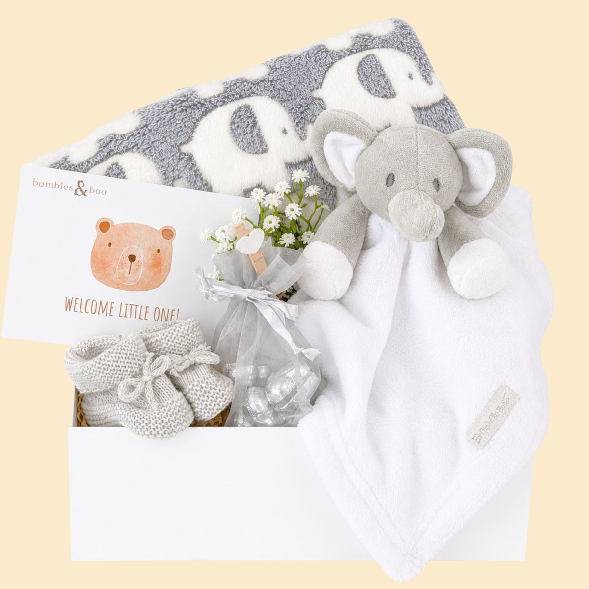 Baby hamper box with gifts including grey blanket with elephant print, white and grey baby comforter and a gift for mum.