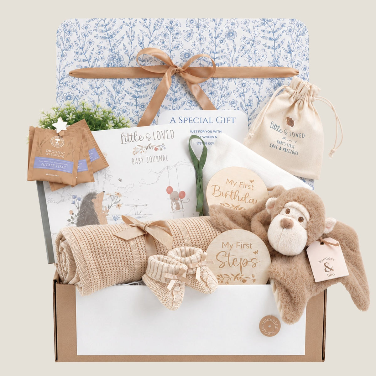 Eco baby hamper gift box with presents including baby journal, booties, blanket and plush monkey toy