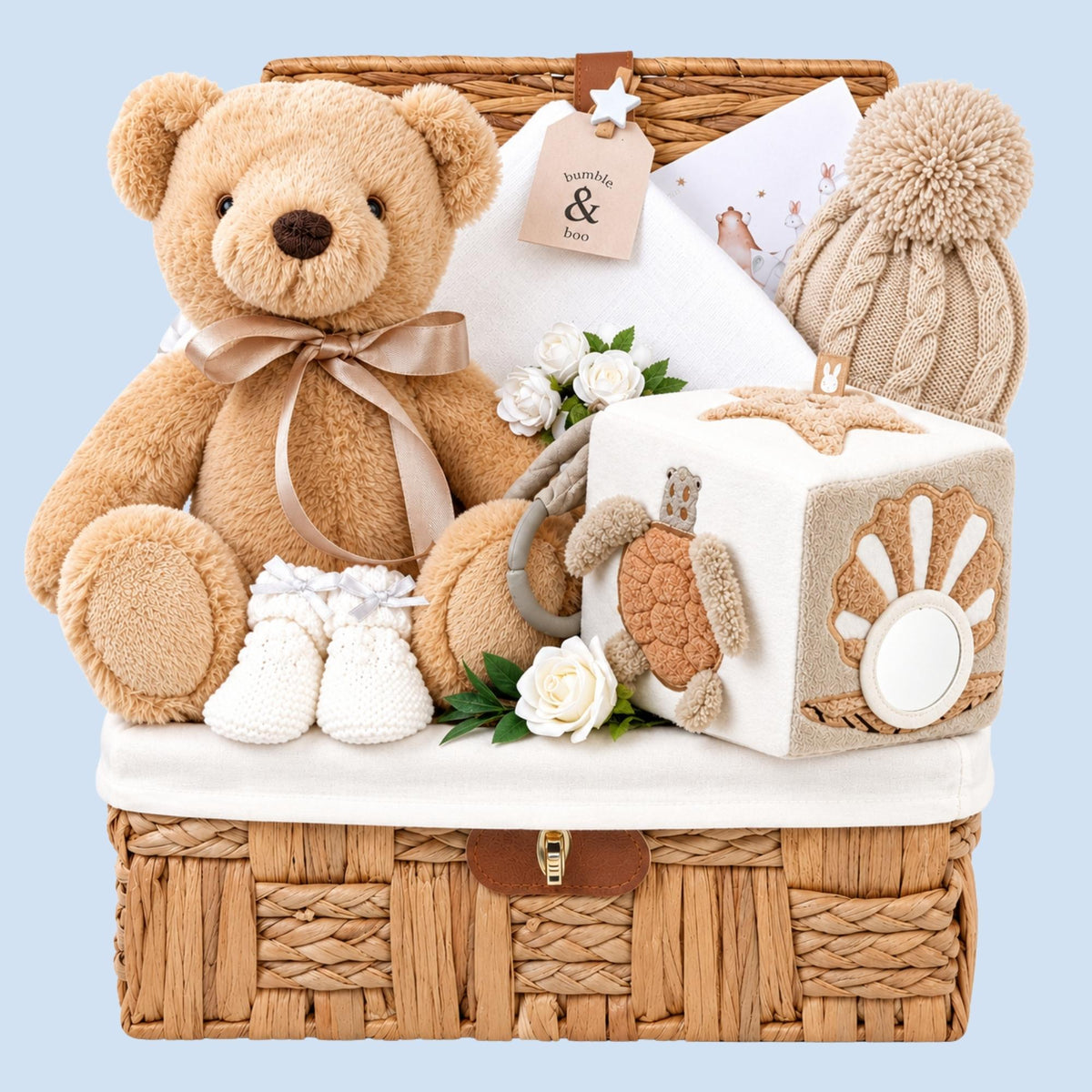New baby hamper basket filled with gifts including teddy bear and activity cube. Packed in a hamper by Bumbles and Boo.