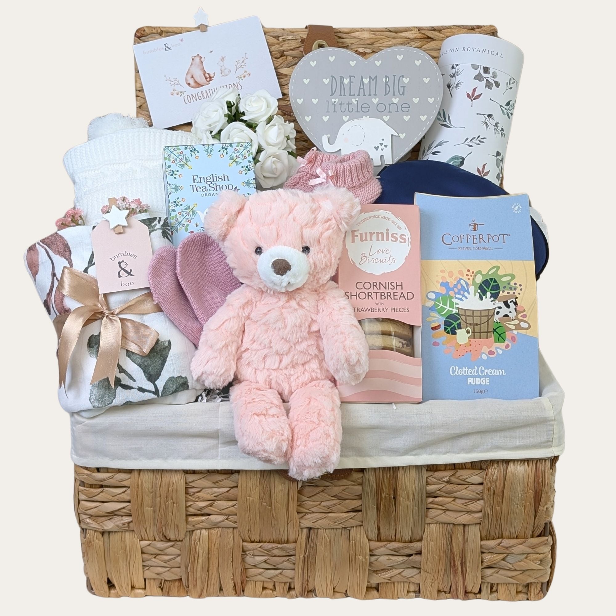 A luxury new mum gifts hamper in a large wicker basket with tea and biscuits and thoughtful pink presents for mum and baby. Bumbles and Boo