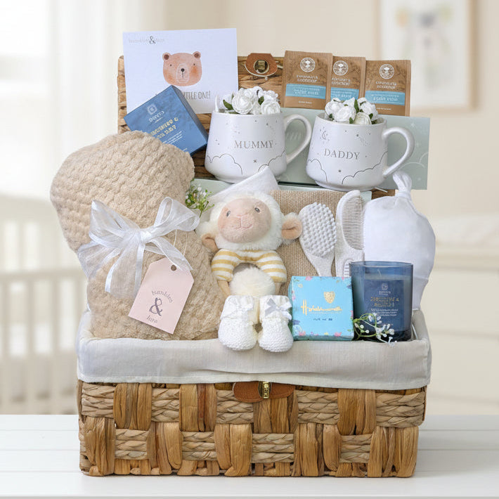 New mum gifts hamper packed with presents including mugs, chocolates, tea, a candle and things for the nursery.