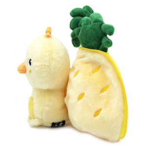 Side view of Nugget the chick beside the opened pineapple shell, showing the green leafy top.