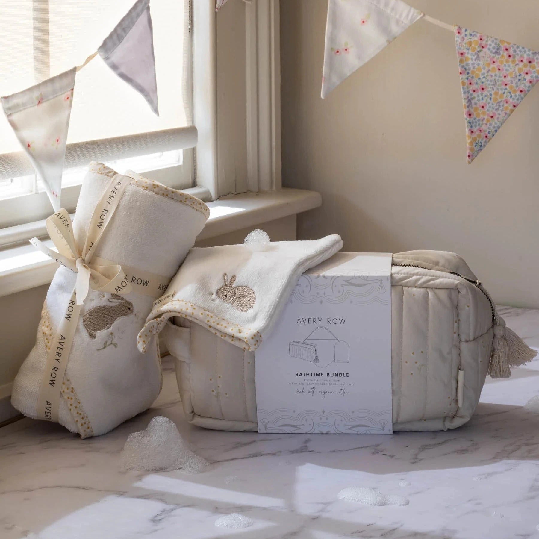 Newborn baby bathtime set from Avery Bow, including a cream quilted bath mat with a bunny applique, a matching cream bath towel and wash mitt.