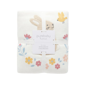 Organic baby blanket showing soft shearling reverse lining and cotton front with bunny embroidery.