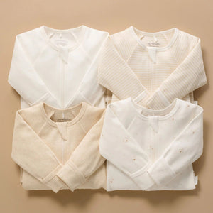 Four pack of neutral baby zip growsuits