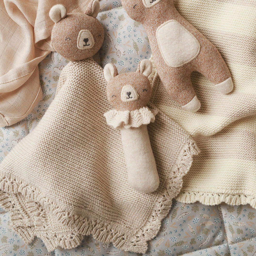 Organic baby comforter toy with a brown bear head and attached blanket, shown with similar toys in the range
