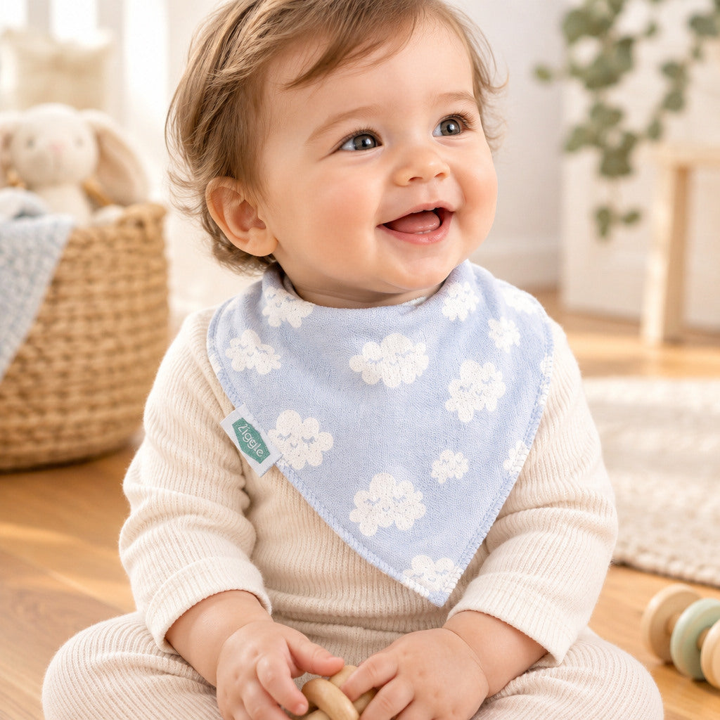 Baby wearing a pale blue bandana bib with white clouds
