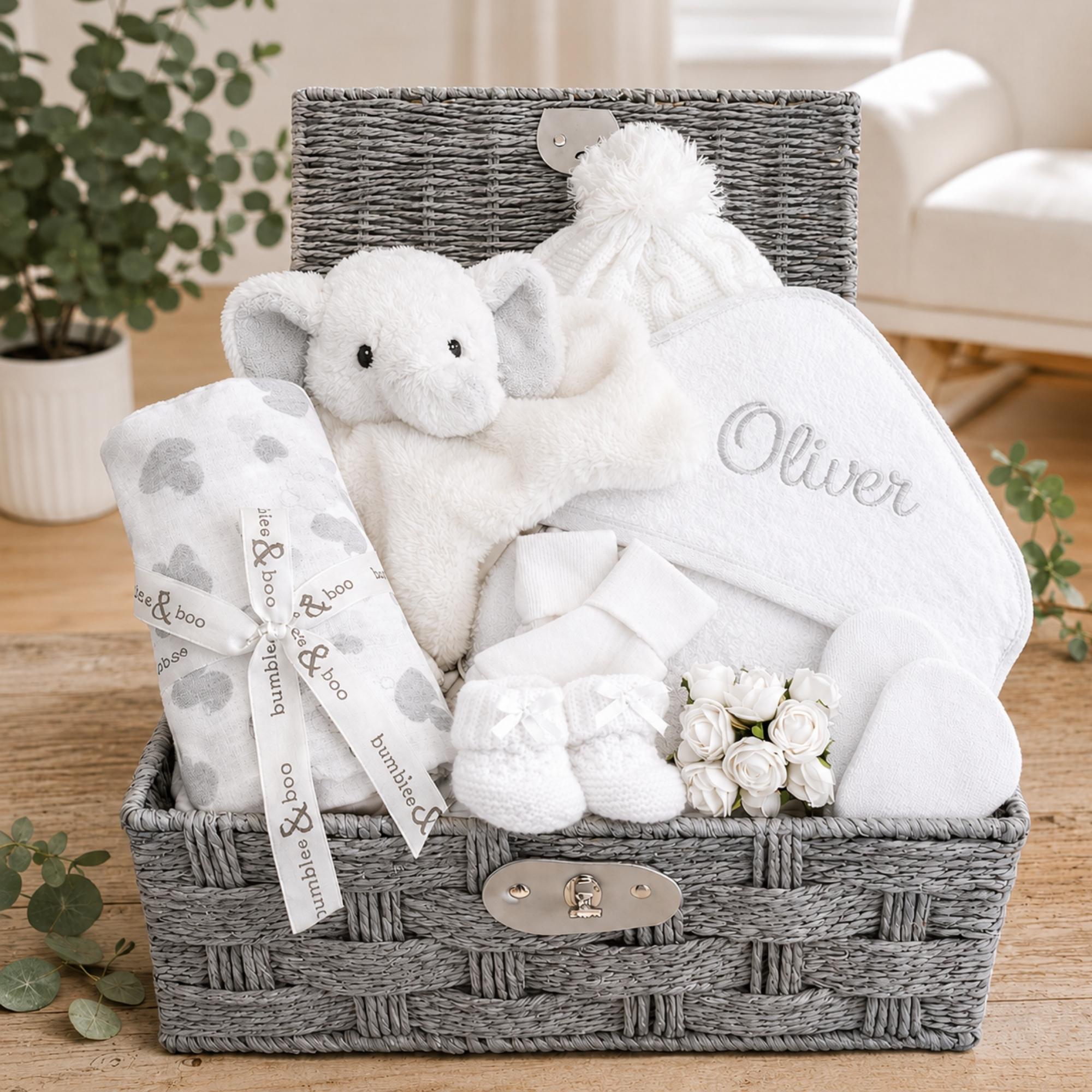 Hamper packed with personalised baby gifts including white and beige presents and elephant comforter