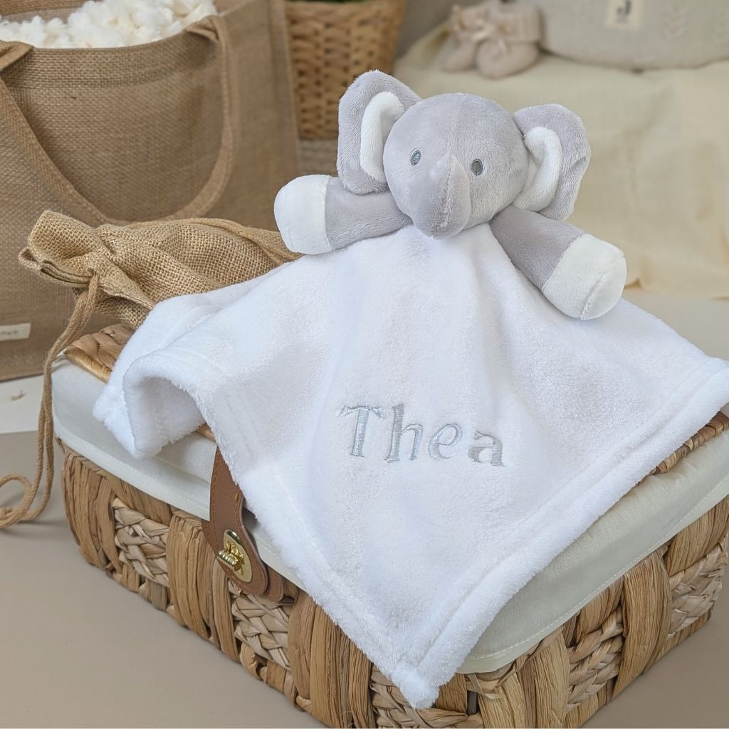 Personalised newborn baby comforter toy with elephant plush attached to the white blanket, embroidered with the name 'Thea'